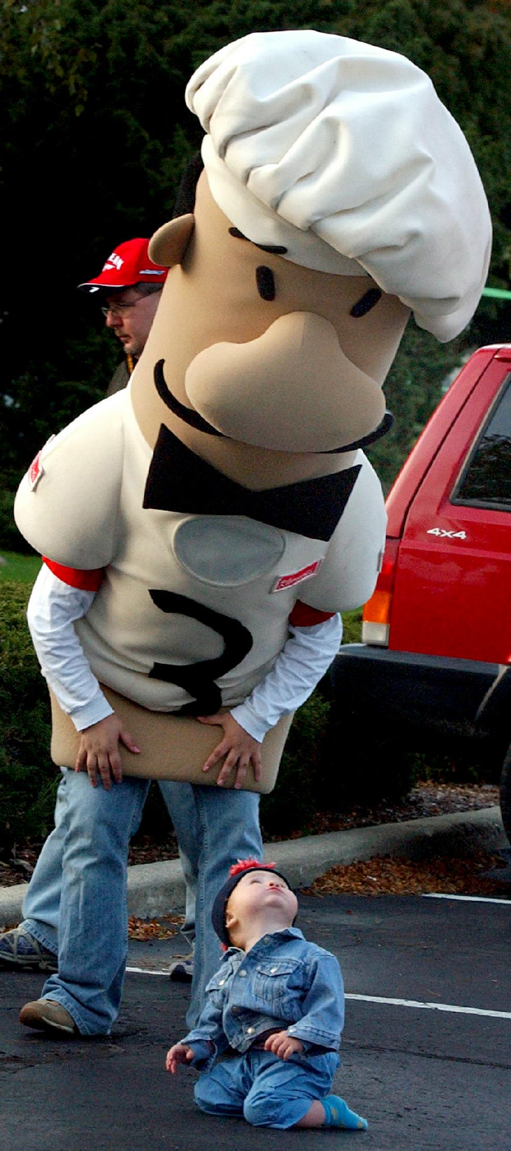In this October 2006, photo, Nolan Crawford, 16 months, looks up at Guido, one of the Milwaukee Brewers' base-running sausages, during a United Way tailgate party in Racine, Wis. Someone wearing the Klement's Racing Italian Sausage costume recently posed with patrons at the Milwaukee Curling Club in Cedarburg. The 7-foot-long, $3,000 costume was in a backroom at the bar during a Feb. 16, 2013, fundraiser. Someone saw the sausage walk out the door that evening and, according to the Journal Sentinel newspaper, it hit two more bars that night but hasn't been seen since. (AP Photo/The Journal Times, Mark Hertzberg)