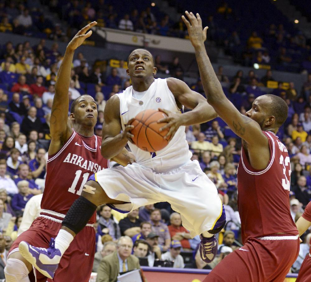 LSU's Anthony Hickey (1) shoots between Arkansas' B.J. Young (11) and Marshawn Powell (33) during their NCAA college basketball game, Wednesday, Feb. 27, 2013, in Baton Rouge, La. LSU won 65-60. (AP Photo/The Advocate, Heather McClelland) MAGS OUT; INTERNET OUT; NO SALES; TV OUT; NO FORNS; LOUISIANA BUSINESS INC. OUT (INCLUDING GREATER BATON ROUGE BUSINESS REPORT, 225, 10/12, INREGISTER, LBI CUSTOM); MANDATORY CREDIT