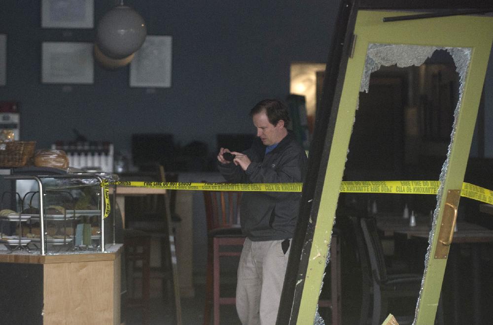 An investigator photographs the interior of the Tomato Head restaurant after a runaway car struck and killed a customer Thursday, Feb. 28, 2013, Knoxville, Tenn. Police say a woman was pronounced dead at a local hospital and the driver of the car was being treated for what appeared to be non-life-threatening injuries. (AP Photo/The Knoxville News Sentinel, Saul Young)