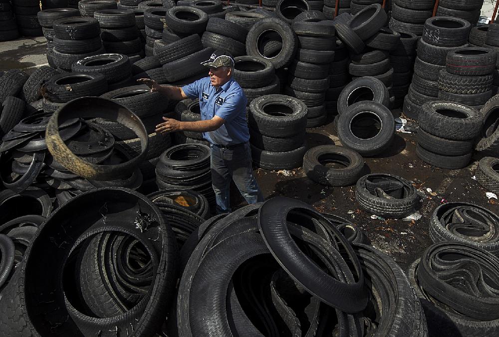 Arkansas Democrat-Gazette/BENJAMIN KRAIN --2/28/2013--
Jose Trujillo with Parker Tire & Auto on Harkrider St. in Conway, disassembles tire sidewalls from treads on scrap tires to reduce mosquito breeding and ensure they are propery recycled according to state law. The Arkansas Waste Tire Program law also requires dealers to pay $2 to the state per new tire sold to fund tire recycling and desposal operations.