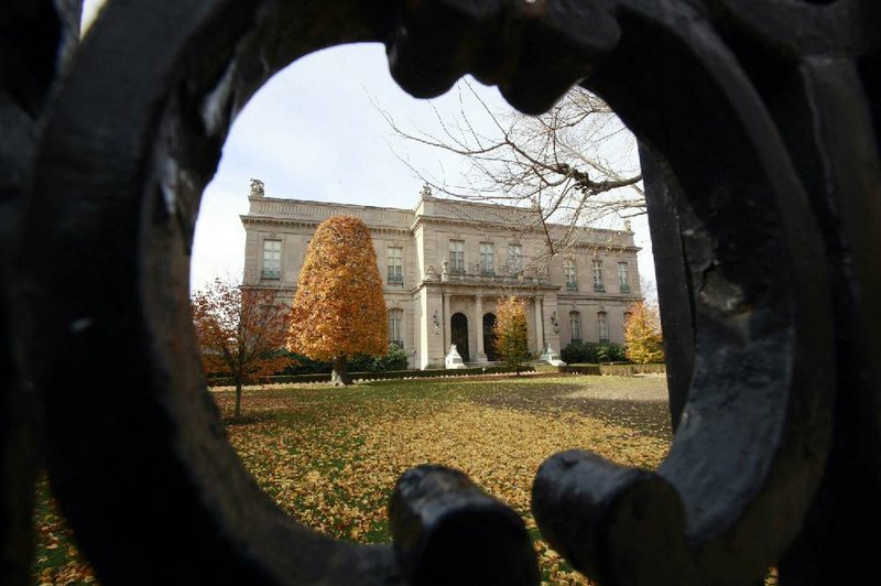 The Elms as it is today is shown through an opening in an iron fence.
