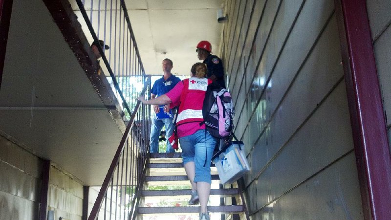 American Red Cross in Arkansas disaster responder Jackie Campbell ascends the stairs after a Little Rock apartment fire to meet with a fire inspector and chief to begin damage assessment and care of displaced families. 