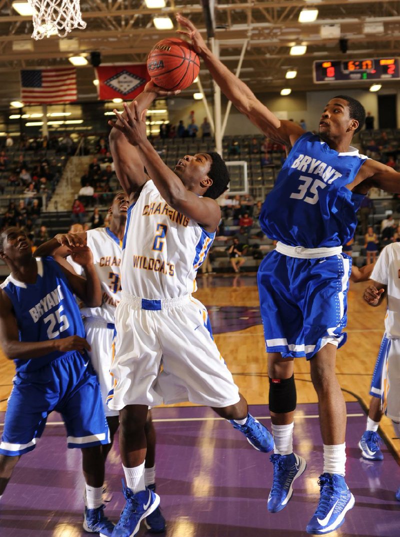 Bryant forward Brian Reed (35, above) blocks a shot by North Little Rock’s Gary Vines in the first half of the Charging Wildcats’ 82-44 victory in the Class 7A state tournament in Fayetteville. North Little Rock used a 50-19 edge in the first and last quarters to nail down the victory.