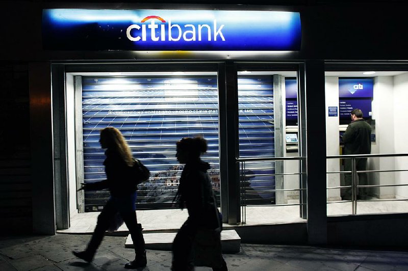 A customer uses a Citibank ATM at a branch bank in Athens, Greece, in November. Citigroup is one of several banks warning shareholders and customers about Internet attacks. 