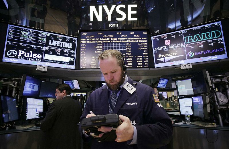 Stock trader Thomas Lyden works Monday on the floor of the New York Stock Exchange. Investors brushed off jitters about a potential slowdown in China and pushed the Dow Jones industrial average to its highest close of the year.