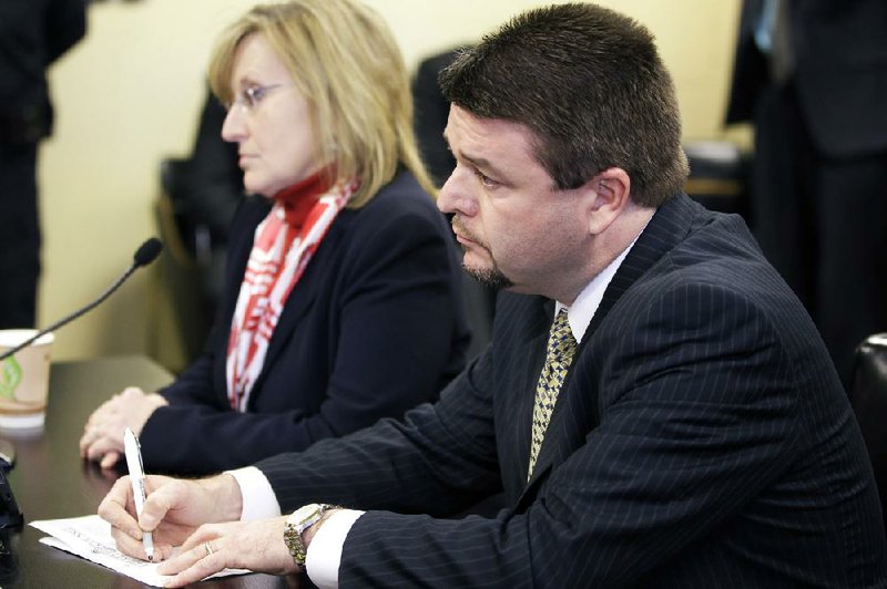 Sen. Jason Rapert, R-Bigelow, right, keeps track of a roll call vote on his bill dealing with abortions after 12 weeks during a meeting of the House Committee on Public Health, Welfare and Labor on Tuesday, Feb. 19, at the Arkansas state Capitol in Little Rock.