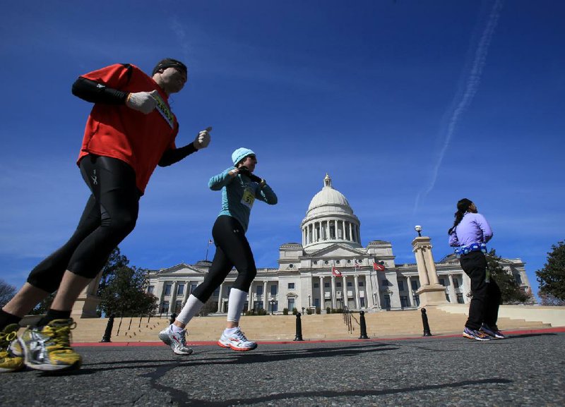 Runners pass in front of the state Capitol almost midway through the 26.2-mile race. 