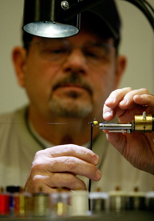 Gary Rowland of Bella Vista teaches an advanced group how to tie a green fuzzy wuzzy fly Monday during a fly tying class led by the Bella Vista Fly Tyers inside Riordan Hall in Bella Vista. 