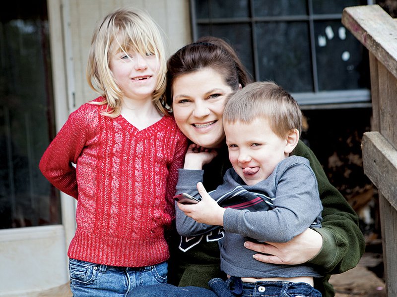 Shannon Branscum and her children, Alison, 6, and Steven, 4, sit on the porch of their home in Twin Groves. Members of the Future Business Leaders of America at Guy-Perkins High School have taken the lead on a project with Habitat for Humanity of Faulkner County to rehabilitate a mobile home for the Branscums. The family also includes Shannon’s husband, Jeremaiah.