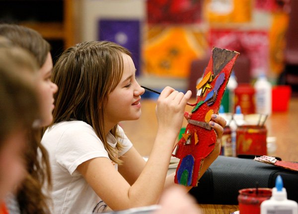 Meagan Yeakley, a sixth-grader, works Friday on her art project at Oakdale Middle School in Rogers. The class, led by Angela Nhu, is designing buildings similar to the paintings and architecture of artist James Rizzi. 