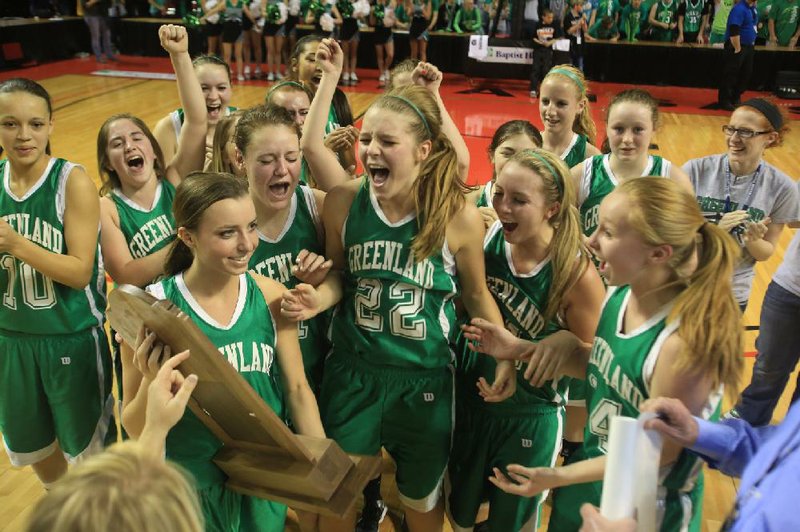 Greenland players surround Kelsey Vaughn (22) as they celebrate with the Class 3A championship trophy after a 59-32 victory over previously undefeated Jessieville. 