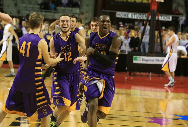 Bay’s Kylor Skaggs (12), Cade Prince (41) and Tyson Oliver celebrate after the final buzzer in the Yellowjackets’ 54-51 victory over Concord in the Class 1A boys state championship game Thursday. 