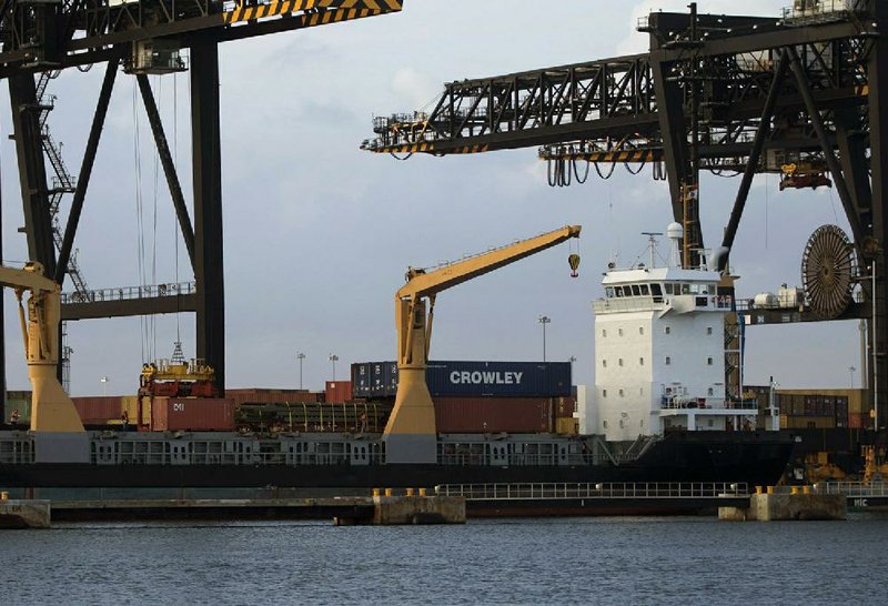 A ship is loaded with cargo at Fort Lauderdale, Fla., in January. The Commerce Department said Thursday that the U.S. trade deficit in January grew more than forecast. 