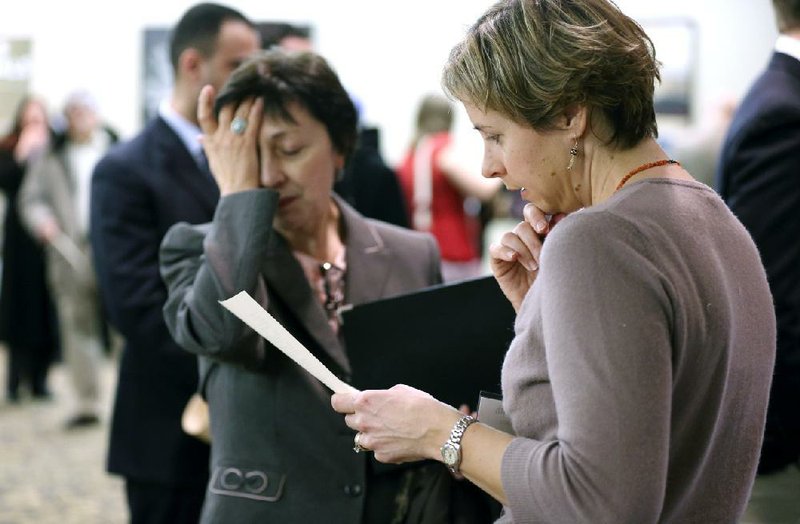 Ann Oganesian (left) of Newton, Mass., speaks with a State Department employee during a job fair in Boston last month. February saw U.S. employers add 236,000 jobs. 