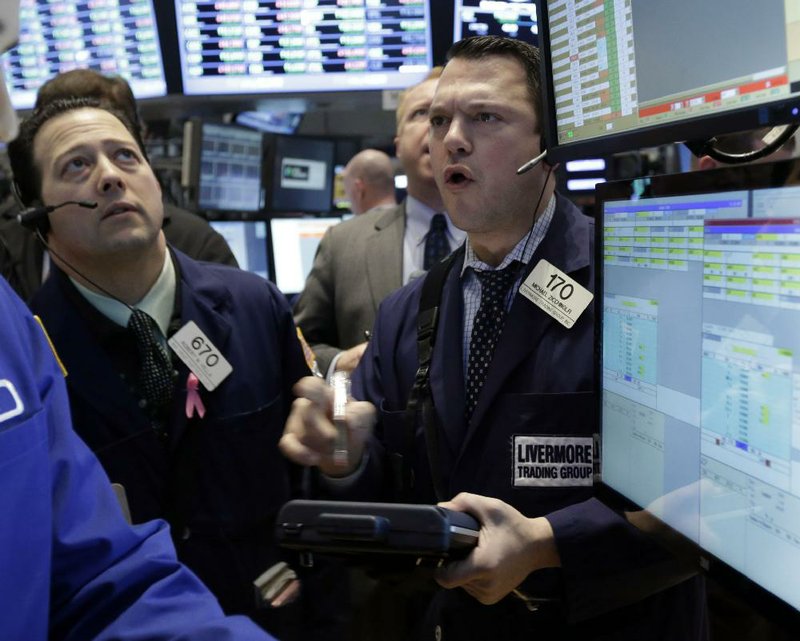 Trader Michael Zicchinolfi (right) works Friday on the floor of the New York Stock Exchange. 