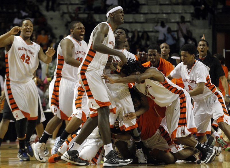 Hall teammates celebrate after Evan James made a last second basket giving Hall a 34-33 victory over Jonesboro in the Class 6A boys high school championship game on Saturday.