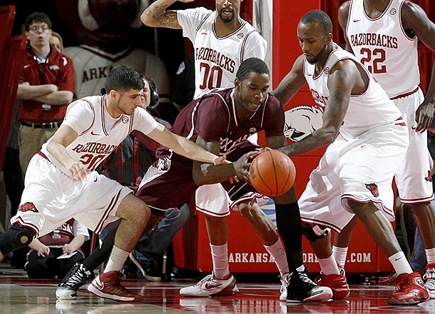 Arkansas juniors Kikko Haydar (left) and Marshawn Powell pressure Texas A&M senior Ray Turner during the first half on Saturday, March 9, 2013, at Bud Walton Arena in Fayetteville.