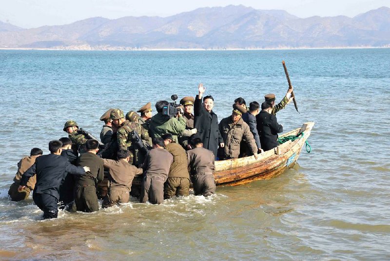 In this March 11, 2013 photo released by the Korean Central News Agency (KCNA) and distributed March 12, 2013 by the Korea News Service, North Korean leader Kim Jong Un waves at military officers after inspecting the Wolnae Islet Defense Detachment, North Korea, near the western sea border with South Korea. North Korea's young leader urged front-line troops to be on "maximum alert" for a potential war as a state-run newspaper said Pyongyang had carried out a threat to cancel the 1953 armistice that ended the Korean War. (AP Photo/KCNA via KNS) JAPAN OUT UNTIL 14 DAYS AFTER THE DAY OF TRANSMISSION