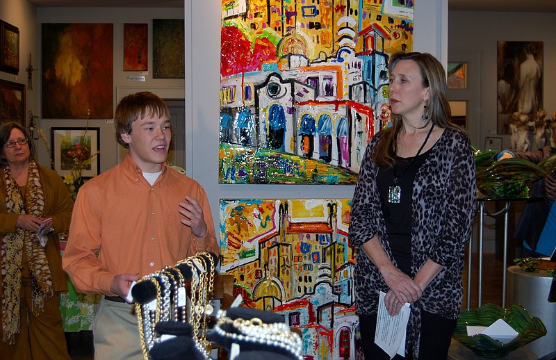 Jacob deLinde, left, who attends Fountain Lake High School, tells Hot Springs Sister City Program Coordinator Mary Neilson and others at a fundraiser on March 7 about his experiences as a member of the Sister City student delegation to Japan last September. The March 7 event at Gallery Central in Hot Springs raised money for scholarships to pay transportation and other costs for students to visit Hanamaki, Japan, later this year.