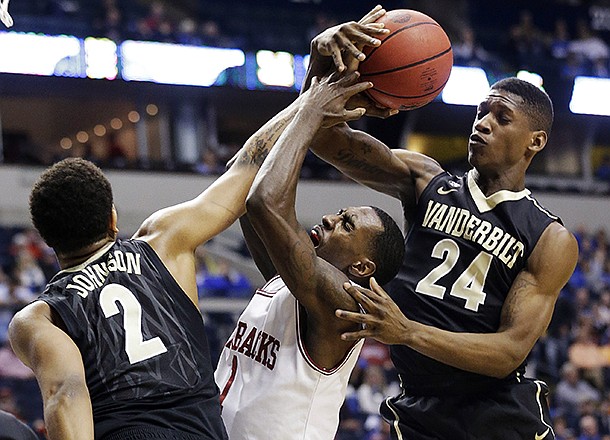 Arkansas guard Mardracus Wade (1) vies for a loose ball with Vanderbilt's Dai-Jon Parker (24) and Kedren Johnson (2) during the first half of an NCAA college basketball game at the Southeastern Conference tournament, Thursday, March 14, 2013, in Nashville, Tenn. (AP Photo/John Bazemore)