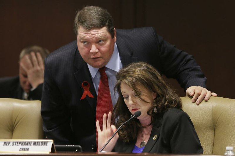 Sen. Bryan King, R-Green Forest, top, speaks with House Rules Committee chair Rep. Stephanie Malone, R-Fort Smith, before a meeting at the Arkansas state Capitol in Little Rock, Ark., Wednesday, March 13, 2013. The committee decided King's bill requiring Arkansas voters to show photo identification can be approved by the Legislature on a simple majority vote. (AP Photo/Danny Johnston)