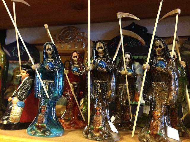 Statues of La Santa Muerte fill a shelf at the Masks y Mas art store in Albuquerque, N.M. Known as the underworld saint, La Santa Muerte is commonly associated with the violent drug trade in Mexico, but interest in the folk saint is spreading throughout the United States. 