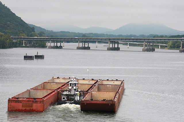  The towboat George Rowe, out of Pine Bluff, pushes 8 empty barges up the Arkansas River toward the I-430 bridge in Little Rock Friday. Pinnacle Mountain is fog-enshrouded in the background (right).