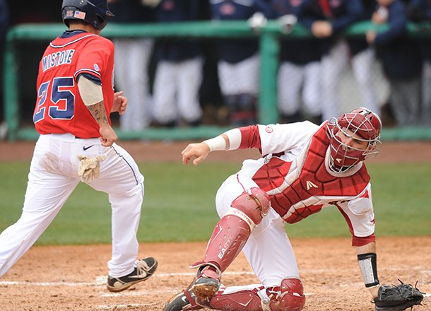 Ole Miss third baseman Andrew Mistone scores as Arkansas catcher Jake Wise loses the throw from the field Sunday, March 17, 2013, during the fourth inning of play against Arkansas at Baum Stadium.