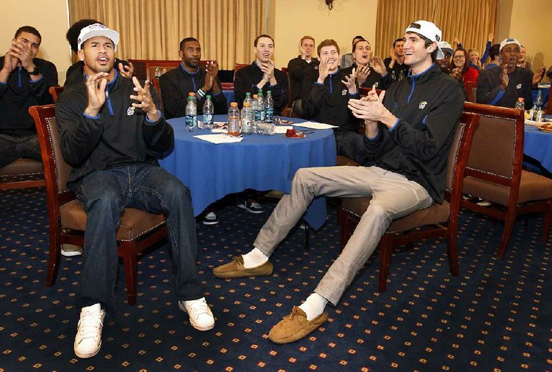 Kansas guard Travis Releford (left) and center Jeff Withey celebrate with teamamates after learning their NCAA tournament assignment during a Selection Sunday viewing party Sunday in Lawrence, Kan. Kansas, a No. 1 seed, is scheduled to face Western Kentucky in the second round on Friday in Kansas City, Mo. 