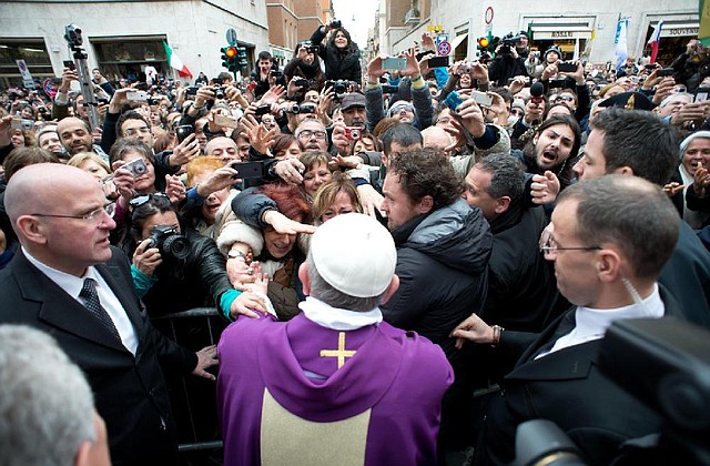 Pope Francis greets the faithful at the Vatican on Sunday. Francis began his first Sunday as pontiff by making an impromptu appearance to the public from a side gate of the Vatican, startling passers-by and prompting cheers. 