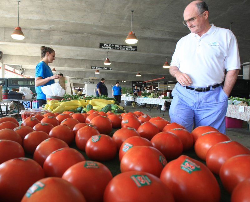 FILE - Fred Roberson (right) buys produce May 26, 2012 at the Little Rock Farmer's Market from Kristi Jensen at Rick's Farm Stand.