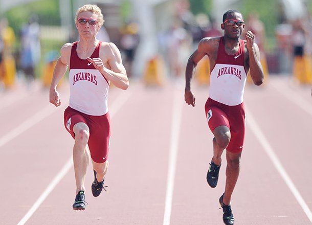 Arkansas' Marek Niit (left) and Akheem Gauntlett race to the finish line in the 100-meter dash during the 2012 Arkansas Spring Invitational track meet at John McDonnell Field in Fayetteville.