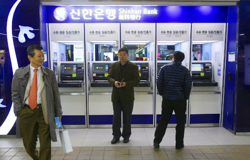 Depositors leave after checking their accounts through automated teller machines of Shinhan Bank at a subway station as the bank's computer networks was paralyzed in Seoul, South Korea, Wednesday, March 20, 2013. Police and South Korean officials were investigating the simultaneous shutdown Wednesday of computer networks at several major broadcasters and banks. While the cause wasn't immediately clear, speculation centered on a possible North Korean cyberattack. (AP Photo/Ahn Young-joon)