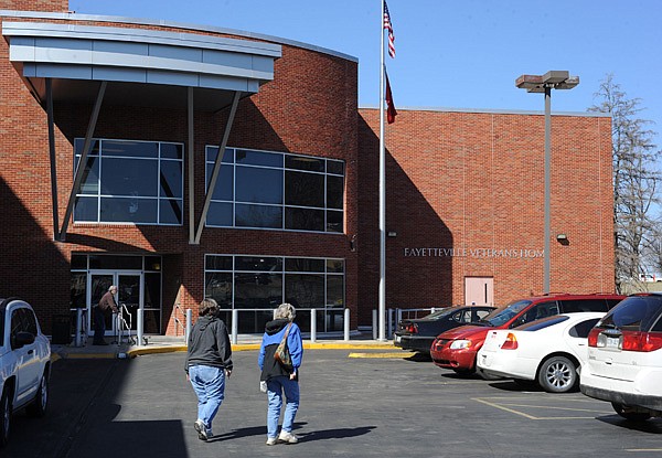 Patients, visitors and staff walk Wednesday outside the Fayetteville Veterans Home. 