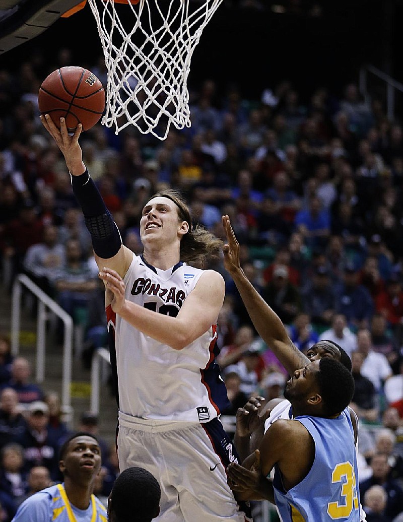 Gonzaga’s Kelly Olynyk (top) puts up a shot in front of Southern’s Brandon Moore (left) during the second half of the Bulldogs’ 64-58 victory over the Jaguars on Thursday in Salt Lake City. 