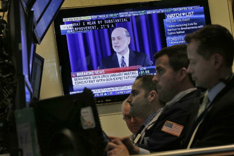 Federal Reserve Chairman Ben Bernanke appears on a television screen on the floor of the New York Stock Exchange on Wednesday during a news conference after the Fed’s two-day meeting. 