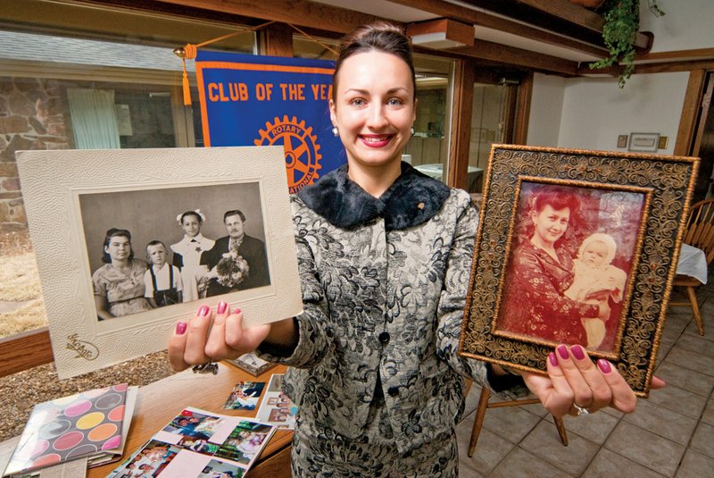 Katherine Ligon holds a photo of her extended family and a photo of being carried as a child by her mother. Ligon moved from the Ukraine to the United States to go to college at Harding University and to earn her master’s degree in teaching. She now teaches at Arkansas State University-Heber Springs and is actively involved in the Cleburne County Rotary Club. She was named outstanding president by Rotary Club International in 2011.