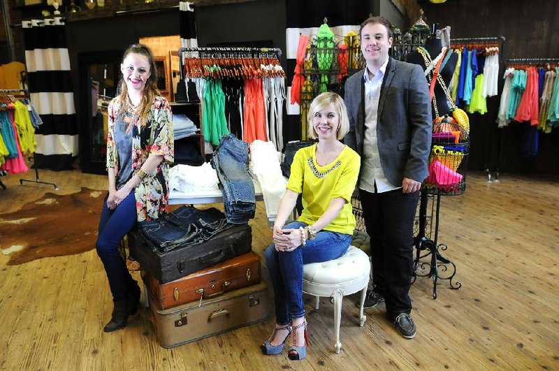 Ashley Miller (from left), general manager of Savoir-Fair, Sara Beck, co-founder and chief executive officer of Btiques, and Will Carter, co-founder and chief operations officer of Btiques, meet last week at Savoir-Fair in Fayetteville. Customers of Savoir-Fair will soon be able to use the Btiques application to buy merchandise from the store. 