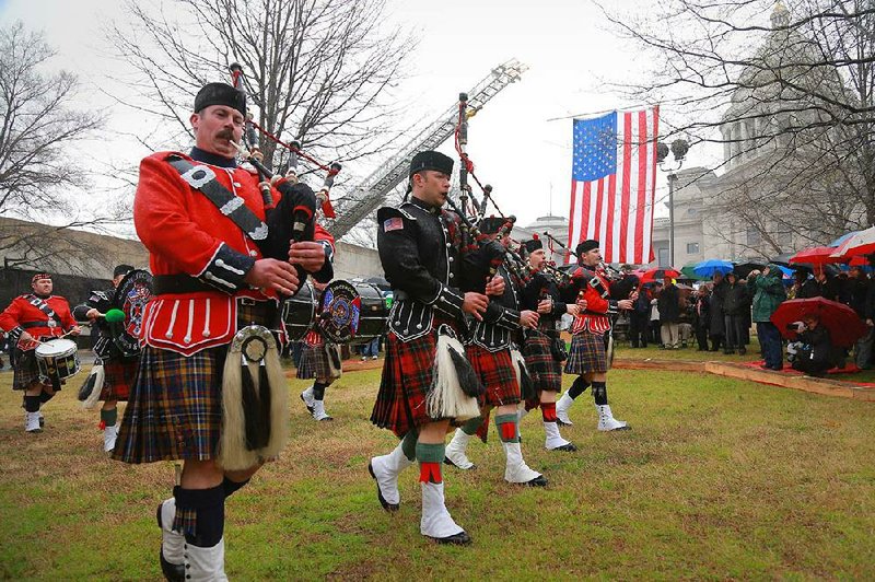 
Members of Pipe and Drum Corps. from Jonesboro, Conway and Little Rock march through a gap in the crowd Saturday afternoon during the ground breaking ceremony of the Arkansas Fallen Firefighters ' Memorial at the State Capitol in Little Rock.