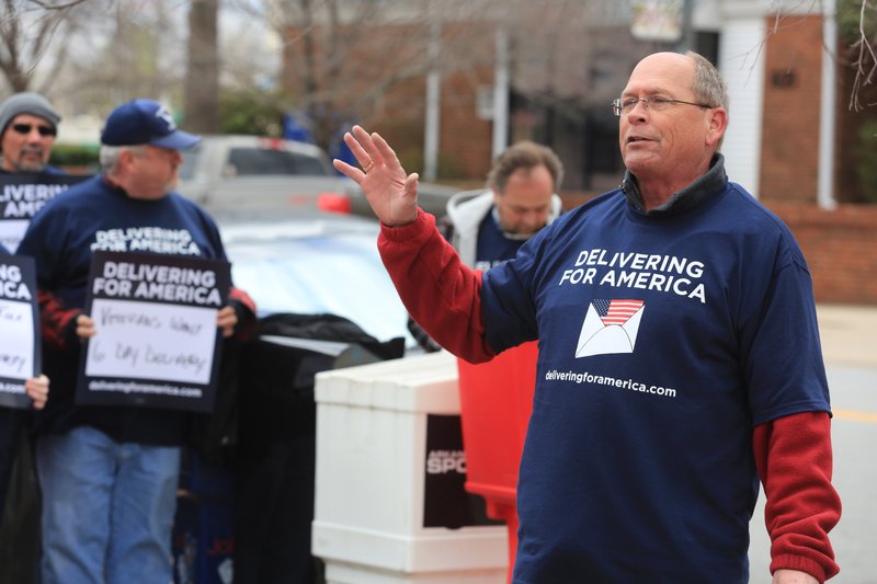 David Anderson, chair of the state Association Letter Carriers leads letter carriers in a cheer supporting 6-day mail delivery during a rally near the Main Branch of the U.S. Post Office in Little Rock Sunday. The National Association of Letter Carriers held a day of protest in every state Sunday against the idea of ending 6-day mail delivery. The U.S. Post Office proposes ending Saturday mail delivery; the letter carriers are against the idea.