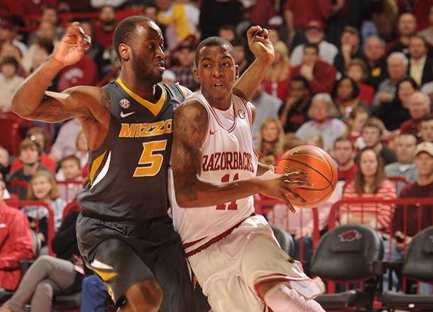 Arkansas sophomore guard BJ Young, right, drives along the baseline as Missouri senior Keion Bell defends Saturday, Feb. 16, 2013, during the first half of play in Bud Walton Arena in Fayetteville.