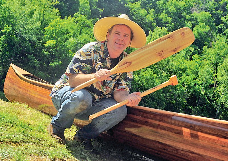 Chris Engholm is shown with the Ballad Hunter, his handmade canoe, below Bull Shoals Dam. The paddle was broken by the strong current.