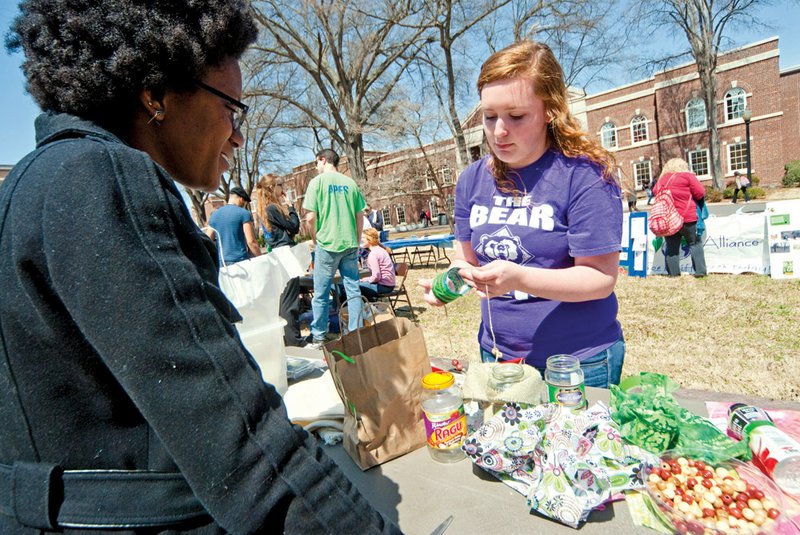 Amanda Brown, right, shows Kendle Carter how to make a small planter from a water bottle during Green Week 2013 at the University of Central Arkansas.