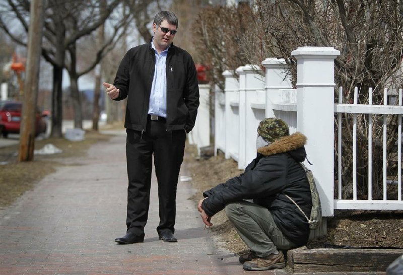 In this March 24, 2013 photo, former Marine Corps Cpl. Marshall Archer, left, a veterans' liaison for the city of Portland, Maine, speaks to a man on a street in Portland. Veterans groups are rallying to fight any proposal to change disability payments as the federal government attempts to address its long-term debt problem.  They say they've sacrificed already. (AP Photo/Robert F. Bukaty)