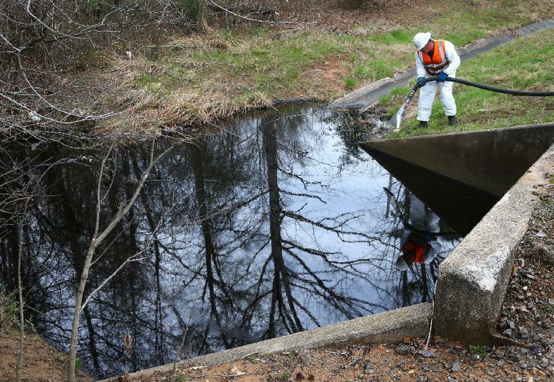 3/29/13
Arkansas Democrat-Gazette/STEPHEN B. THORNTON
David Thomas, with FCC Environmental, uses a large vacumn line to suck thick black oil from a creek, just 40 yards east of I-40, which feeds into Lake Conway in Mayflower Friday afternoon at a nearby pipeline break. The creek was just a few hundred yard south of the Mayflower exit at Hwy 89.