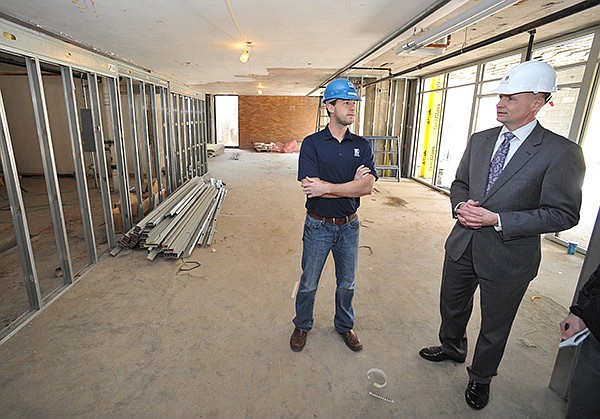  Jeffery Vinger, University Housing's director for residential facilities (right) and Chase Taylor, project manager with Kinco Constructors of Springdale show one of the improved areas on the main floor of Hotz Hall on the University of Arkansas campus Wednesday afternoon.  Hotz Hall is one of four housing projects University of Arkansas officials have planned between now and 2020. Hotz and Founders halls are expected to open this fall and add approximately 630 bedrooms on campus