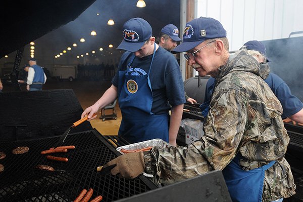 Retired Army Maj. Ken Selby, right, and Christian Henning, 14, both members of the Sons of the American Legion, cook hamburgers and hot dogs Saturday, March 30, 2013, at the Pauline Whitaker Animal Science Arena in Fayetteville during the 2nd annual Welcome Home Veterans Picnic. The event was hosted by the Veterans of Foreign Wars, the American Legion, U.S. Submarine Veterans and the Northwest Arkansas Women Veterans.