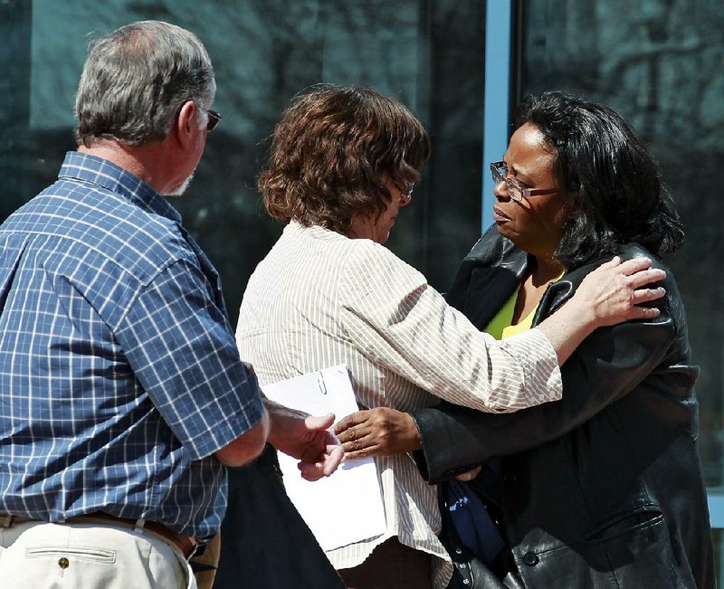 Sherry Delaney (right) hugs Arlene Holmes on Monday as she and Robert Holmes (left) leave the courthouse in Centennial, Colo., after attending hearings in the case against their son, Aurora theater-shooting suspect James Holmes. 