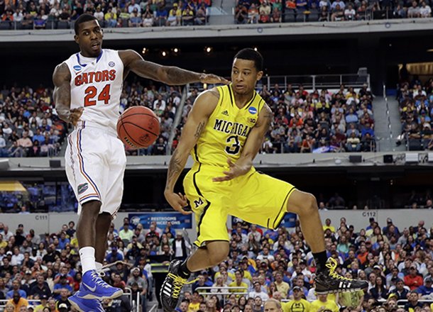 Michigan's Trey Burke (3) passes the ball to Tim Hardaway Jr. (10) in front of Florida's Casey Prather (24) during the second half of a regional final game in the NCAA college basketball tournament, Sunday, March 31, 2013, in Arlington, Texas. (AP Photo/David J. Phillip)