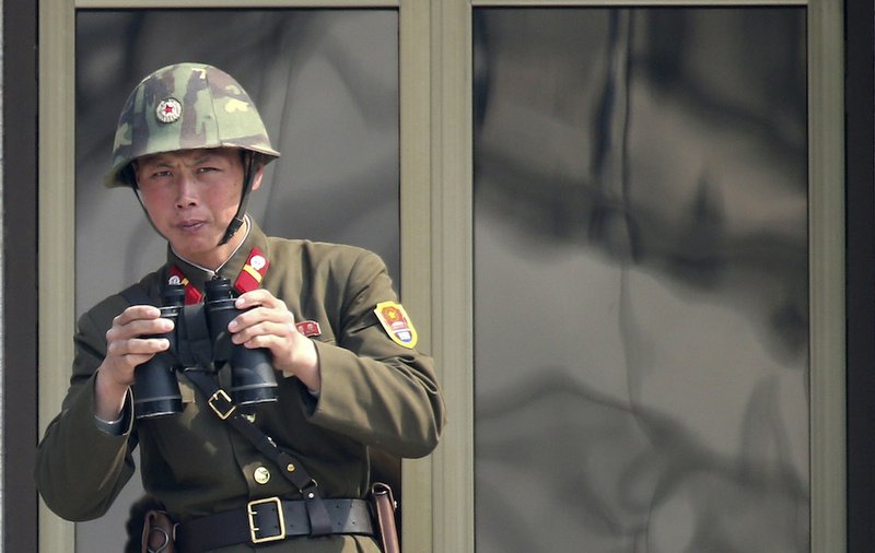 A North Korean soldier watches the South Korean side at the border village of Panmunjom in the demilitarized zone (DMZ) in South Korea Thursday, April 4, 2013. South Korea's defense minister said Thursday North Korea has moved a missile with "considerable range" to its east coast, but said it is not capable of hitting the United States.